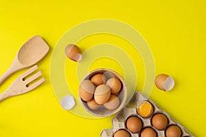 Eggs and kitchenware on yellow background