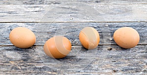 Eggs are lined up on a wooden table