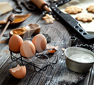 Eggs in metal egg stand and other ingredients for cooking gingerbread christmas cookies