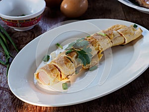 Eggs omelet rolls with sausage on wooden background