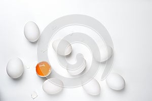 Eggs.One cracked with shell and group of whole unheard eggs on the white background. photo