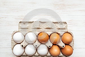 Eggs in open carton pack on wooden surface