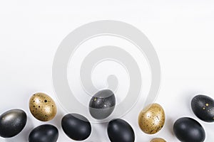 Eggs painted gold and black on white background. Minimal Easter concept with copy space for text.