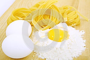 Eggs, pasta and flour on wooden desk
