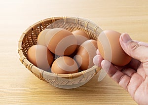 Eggs placed against a wooden background and held in the hand