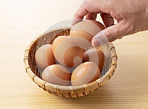 Eggs placed against a wooden background and held in the hand