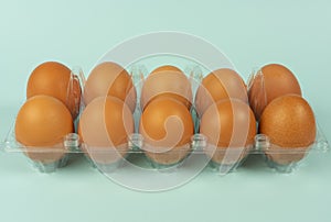 Eggs in a plastic package with isolated turquoise background