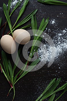 Eggs and Ramson on a black table, wood garlic and flour