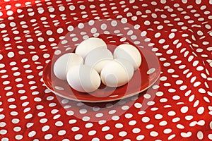 Eggs on a red plate on red background