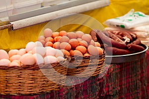 Eggs and sausages in baskets at the farmer`s market