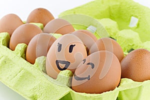 Eggs with smiley faces in eggbox photo