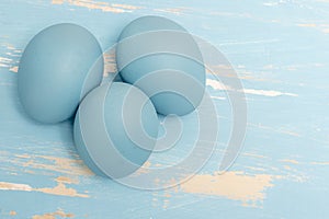 Eggs symbolizing the Easter holiday in blue color on a background of aged wood