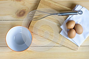 Eggs with whisk and empty ornage bowl