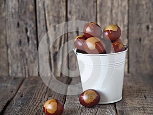 Eggs in a white bucket on a wooden background. The concept of preparing for the Easter holiday