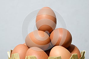 Eggs on white cement wall background - Many eggs in a small bamboo basket on the gray wooden floor, Chicken eggs contain protein