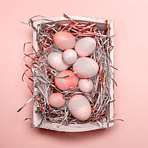 Eggs in a white tray. Creative Easter concept. Modern solid pink background. . Living coral theme - color of the year 2019