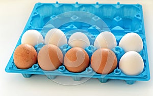 Eggs are white and yellow in the open blue plastic container