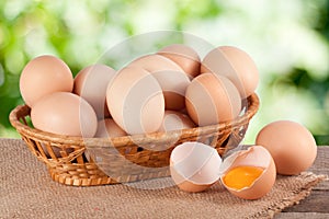 Eggs in a wicker basket on a wooden board with blurred garden background