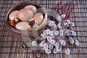 Eggs and willow branches on a wooden background