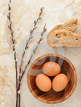 Eggs in a wooden plate, bread pita and willow twigs