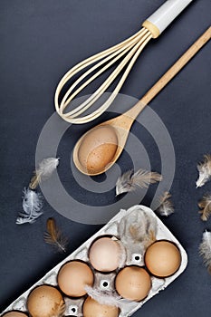 Eggs, wooden spoon, whisker and feathers