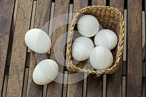Eggs on wooden table and basket