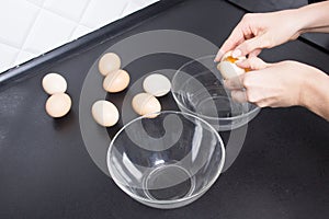 Egs in woman hands and glass bowls on kitchen photo