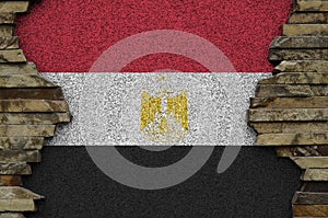 Egypt flag depicted in paint colors on old stone wall closeup. Textured banner on rock wall background