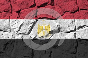 Egypt flag depicted in paint colors on old stone wall closeup. Textured banner on rock wall background