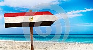 Egypt flag on wooden table sign on beach background. It is summer sign of Egypt