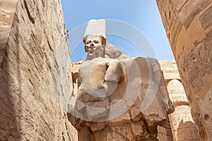 Egypt Luxor Temple. granite Statue of Ramses II seated in front of columns