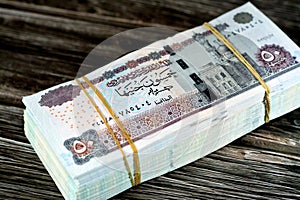 Egypt money stack of pounds isolated on wood background, pile of 50 EGP LE fifty Egyptian pounds cash money bills with a image of