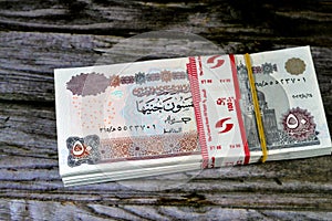 Egypt money stack of pounds isolated on wood background, pile of 50 EGP LE fifty Egyptian pounds cash money bills with a image of