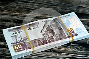 Egypt money stack of pounds  on wood background, pile of 50 EGP LE fifty Egyptian pounds cash money bills with a image of