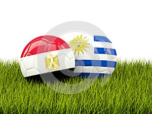 Egypt vs Uruguay. Soccer concept. Footballs with flags on green