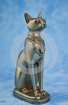 Egyptian cat Bast or Bastet, solar and war goddess, isolated on blue