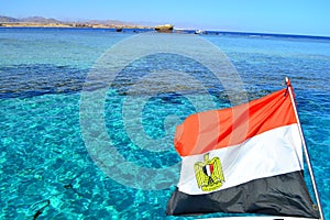 Egyptian flag on the background of the Red Sea. Flag of Egypt on background of sea and Tiran island,Sharm El Sheikh, Egypt