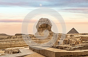 Egyptian Great Sphinx full body portrait with head, feet with all pyramids of Menkaure, Khafre, Khufu in background on a clear,