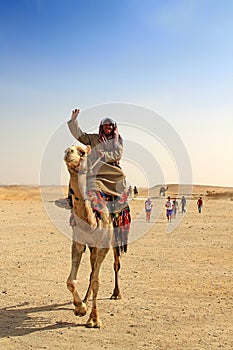 Egyptian guide offering to tourists camel ride