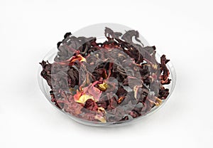 Egyptian hibiscus dry red tea (karkade) on a transparent round plate