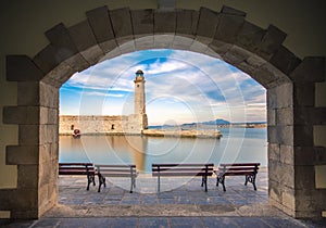 The Egyptian lighthouse at the old harbor of Rethimno through a frame of an arched door, Crete.