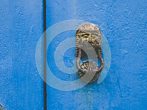 Egyptian metal door knocker on an old blue door