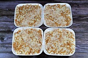 Egyptian rice with vermicelli cooked on hot steam served in a disposable plate and isolated on wooden background, the vermicelli