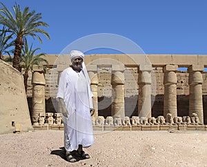 An Egyptian temple with an ancient Egyptian in the foreground.