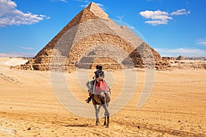 Egyptians on camels near the complex of Giza Pyramids, Egypt photo