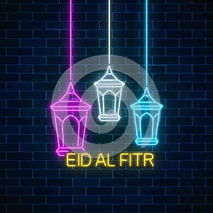 Eid al fitr greeting card with with fanus lanterns. Glowing neon ramadan holy month sign on dark brick wall background.