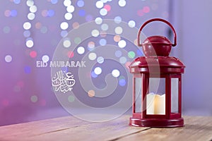 Eid al-Fitr Mubarak Greeting Typography with Bokeh backgound. Arabic lantern on wooden backgound photo