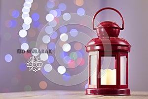 Eid al-Fitr Mubarak Greeting Typography with Bokeh backgound. Arabic lantern on wooden backgound