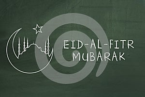 Eid-Al-Fitr mubarak text on green blackboard. Welcoming ramadan.