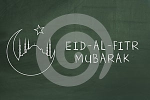 Eid-Al-Fitr mubarak text on green blackboard. Welcoming ramadan. photo